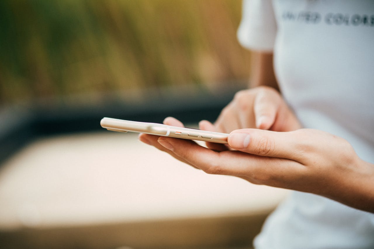 smartfon z uszkodzonym mikrofonem trzymany w rękach przez kobietę
