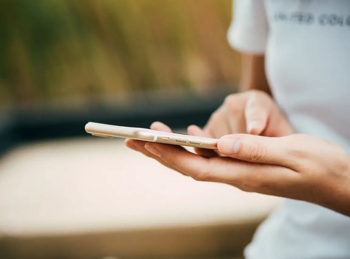 Osoba trzymająca smartfon w dłoniach i dotykająca ekranu, telefon nie reaguje.